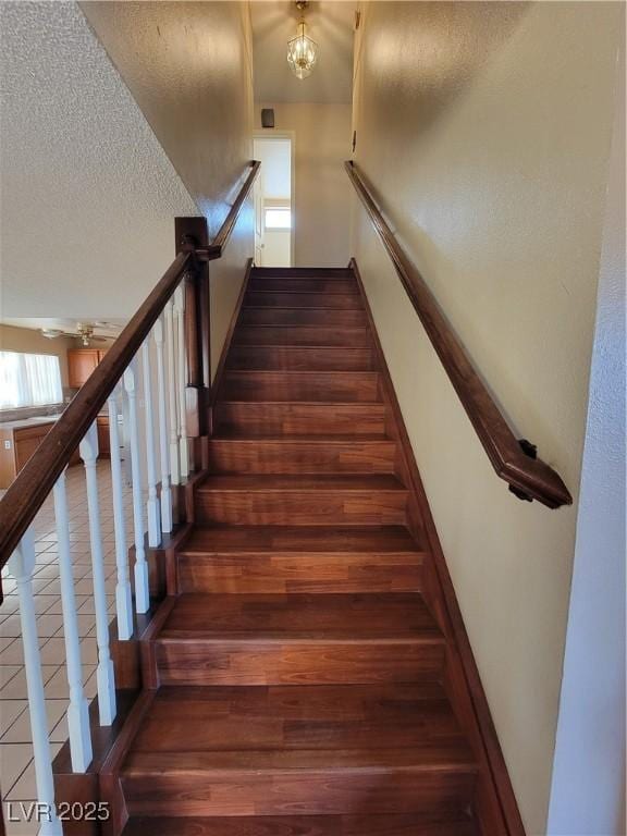 stairs with a textured ceiling