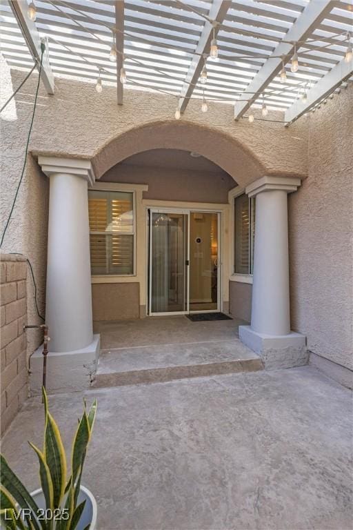 property entrance with a pergola