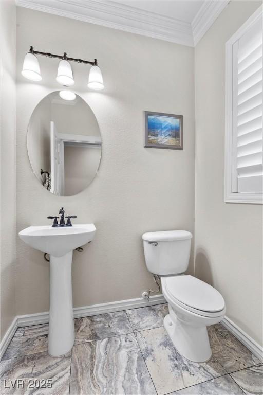 bathroom with ornamental molding and toilet