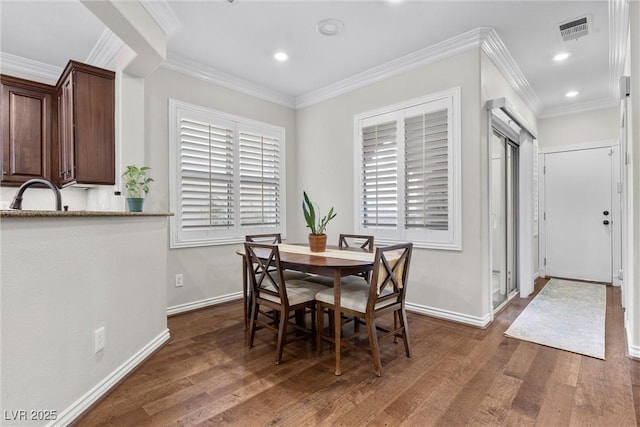 dining room with crown molding, dark hardwood / wood-style flooring, and sink