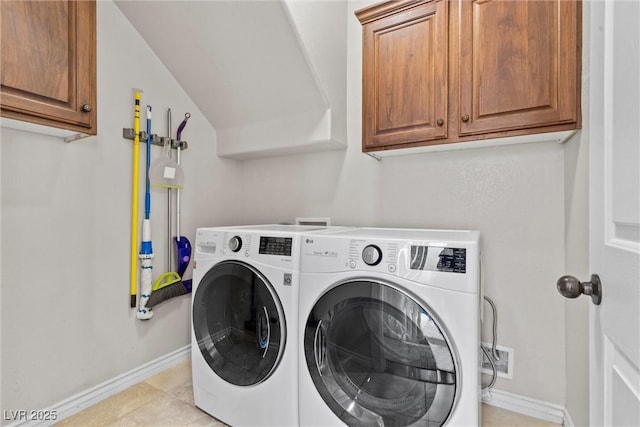 laundry area featuring cabinets, light tile patterned floors, and independent washer and dryer