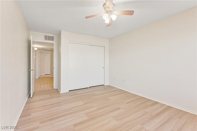 unfurnished bedroom with light hardwood / wood-style floors, a closet, and ceiling fan