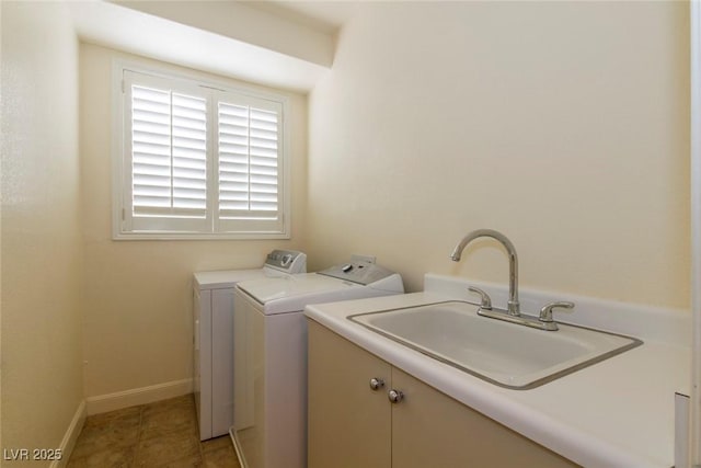 washroom with sink, cabinets, and washer and dryer