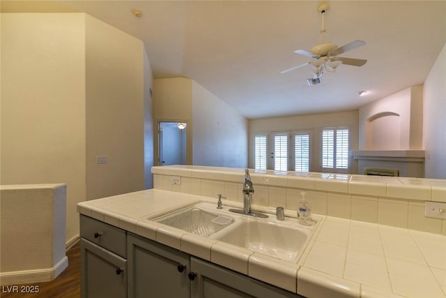 kitchen with sink, dark hardwood / wood-style flooring, tile counters, gray cabinets, and ceiling fan