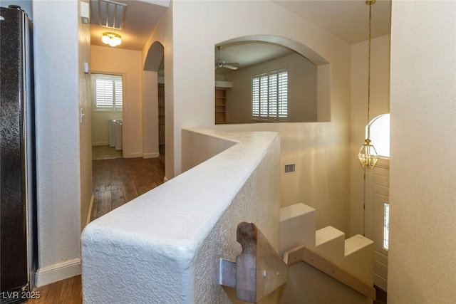 stairway with ceiling fan, wood-type flooring, and plenty of natural light