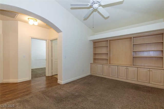 unfurnished living room with lofted ceiling, ceiling fan, and dark colored carpet