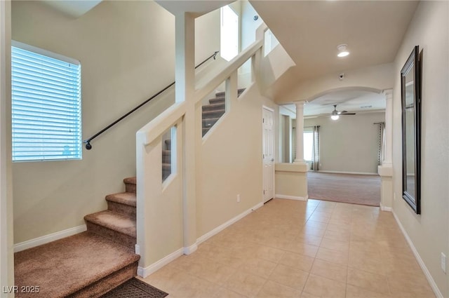 stairway featuring ceiling fan, tile patterned floors, and decorative columns