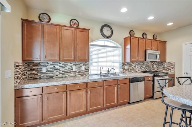 kitchen with tasteful backsplash, sink, a breakfast bar area, and stainless steel appliances