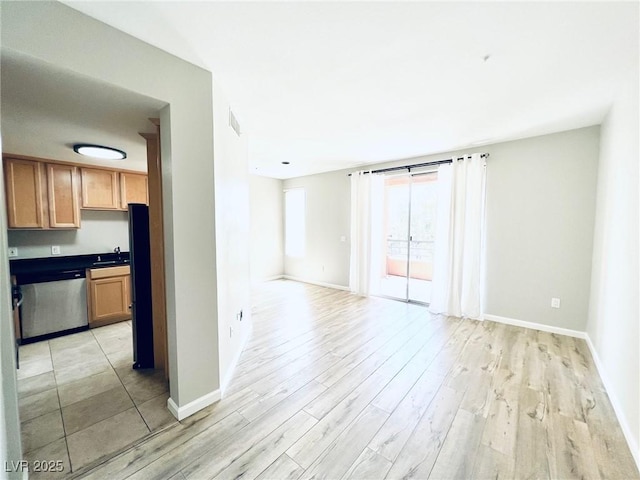 spare room with sink and light hardwood / wood-style floors