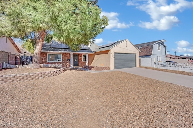 ranch-style home with a garage and solar panels