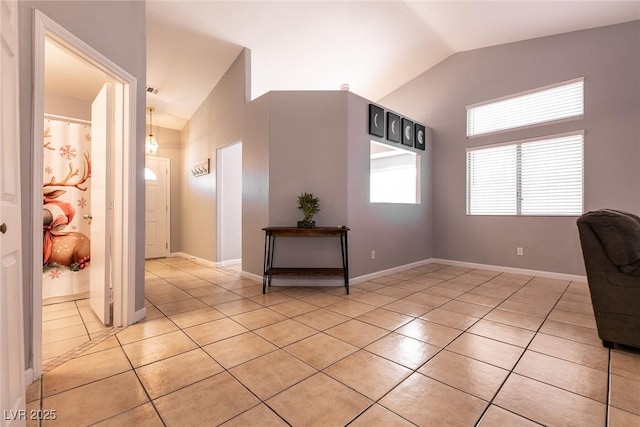 unfurnished office with vaulted ceiling and light tile patterned floors