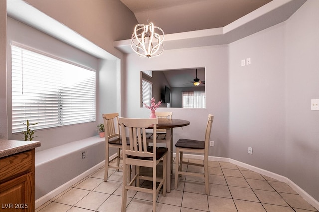 tiled dining room featuring ceiling fan with notable chandelier and a wealth of natural light