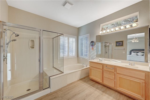 bathroom featuring vanity, separate shower and tub, and hardwood / wood-style floors