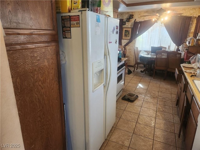 kitchen with light tile patterned floors and white refrigerator with ice dispenser