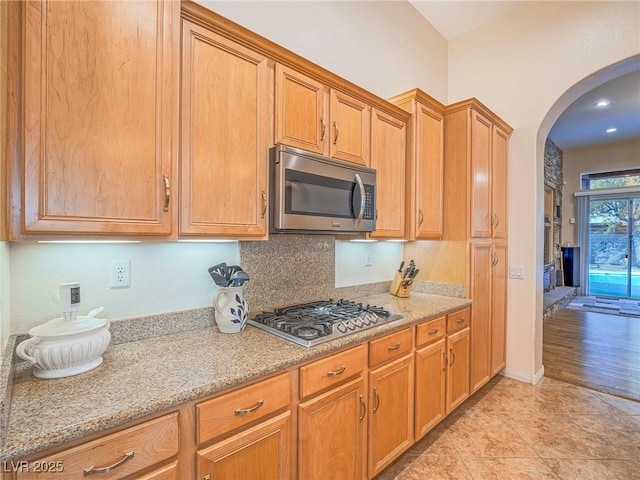 kitchen with light tile patterned flooring, appliances with stainless steel finishes, and light stone countertops