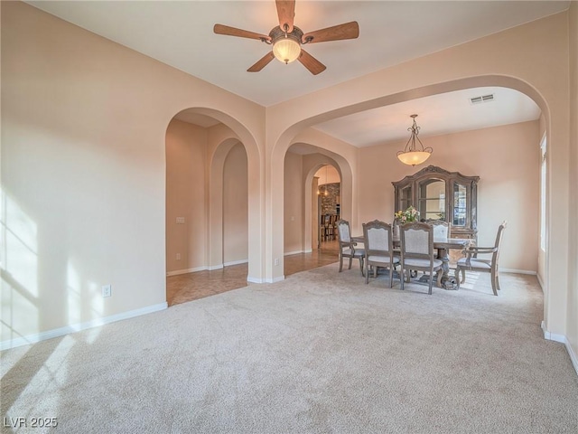 carpeted dining area with ceiling fan