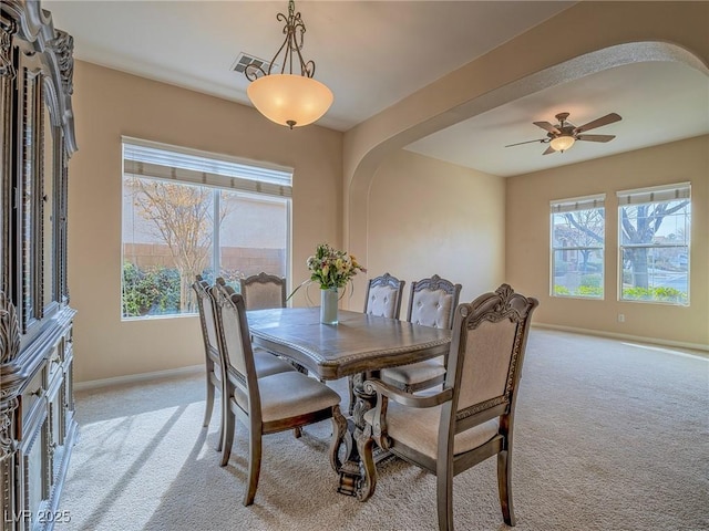 carpeted dining space with ceiling fan