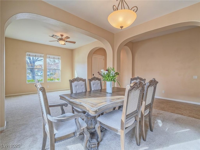 carpeted dining area with ceiling fan