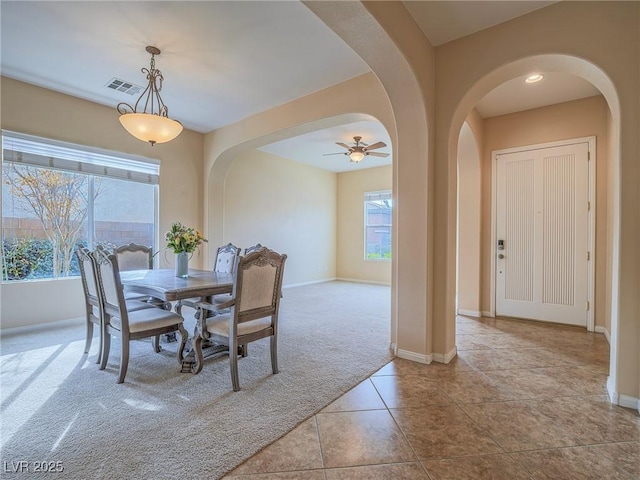 dining space with light carpet and ceiling fan