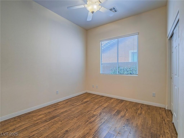 empty room featuring ceiling fan and dark hardwood / wood-style flooring