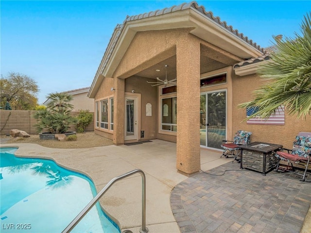 exterior space featuring a patio, ceiling fan, and a fire pit