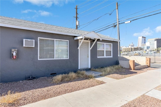 bungalow-style home featuring an AC wall unit