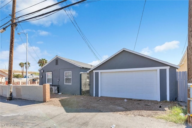 view of front of home with an outbuilding, a garage, and central AC