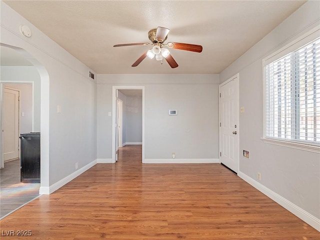 unfurnished room featuring ceiling fan, plenty of natural light, and light wood-type flooring