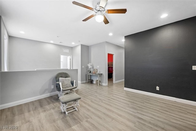 living area featuring ceiling fan and light hardwood / wood-style flooring