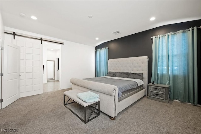 carpeted bedroom featuring a barn door