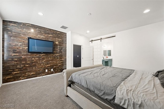 carpeted bedroom with connected bathroom and a barn door