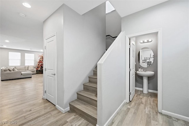 stairway featuring sink and wood-type flooring