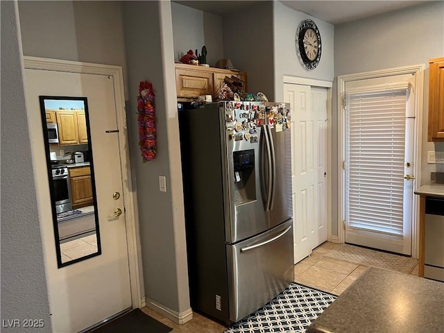 kitchen featuring stainless steel appliances and light tile patterned flooring