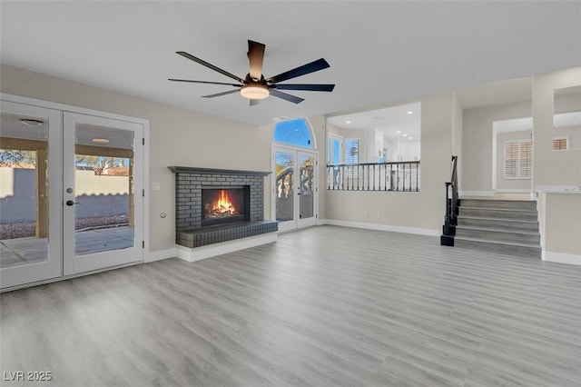 unfurnished living room with french doors, a healthy amount of sunlight, and light hardwood / wood-style floors