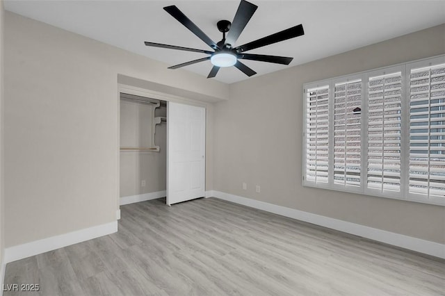 unfurnished bedroom with light hardwood / wood-style flooring, ceiling fan, and a closet