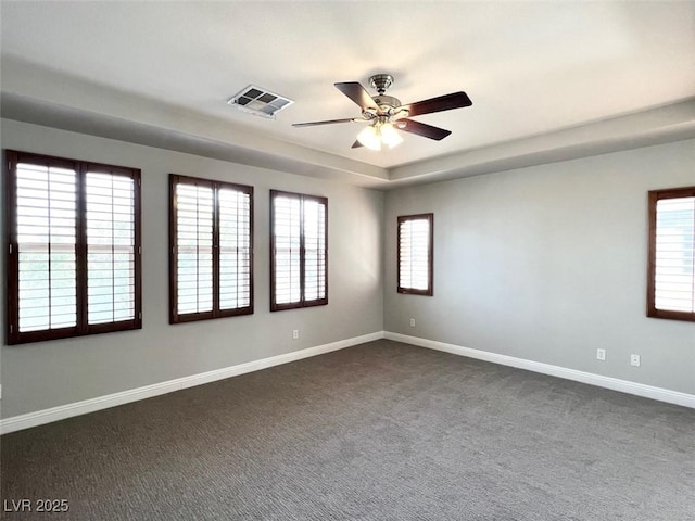 carpeted spare room with ceiling fan and a tray ceiling