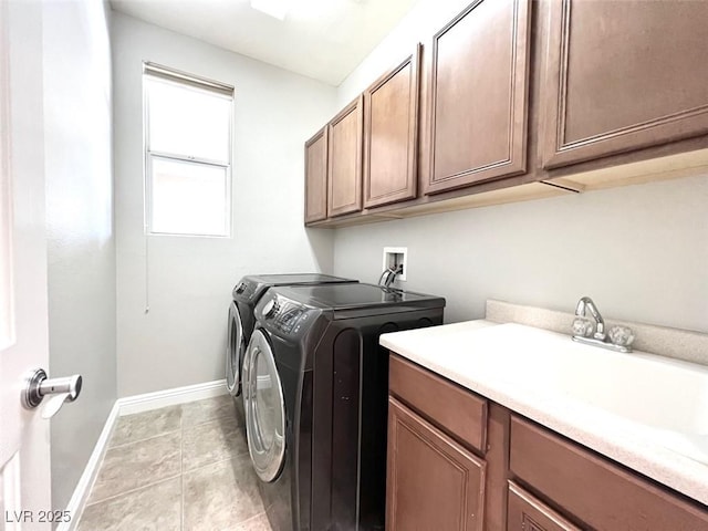 laundry area with cabinets, washing machine and dryer, and light tile patterned floors