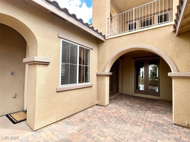 property entrance featuring french doors and a patio area