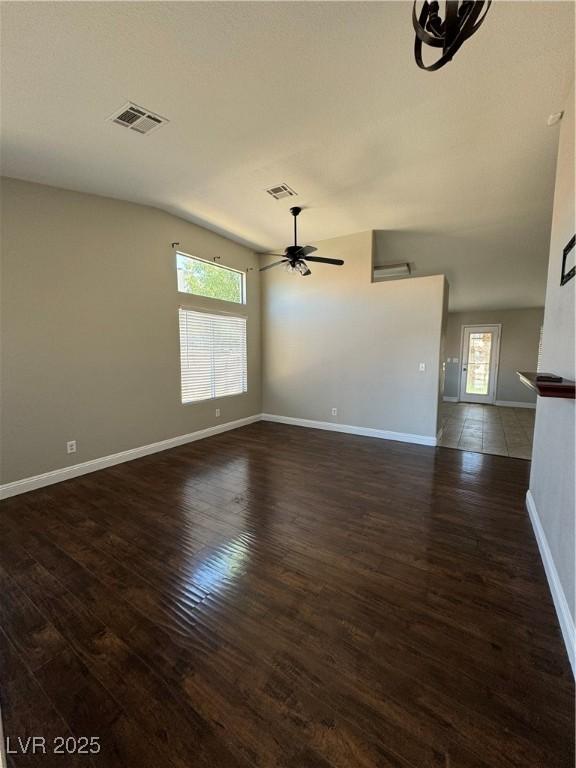 empty room featuring dark wood-type flooring and ceiling fan