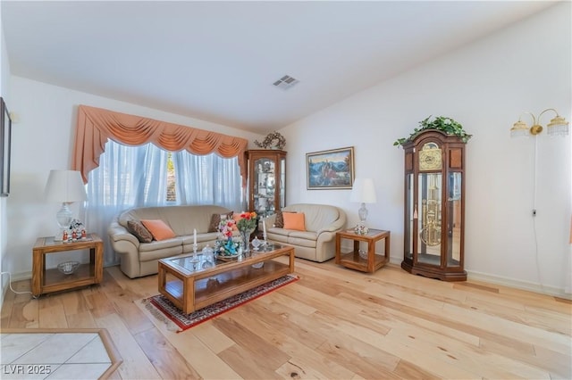 living room featuring vaulted ceiling and light hardwood / wood-style flooring