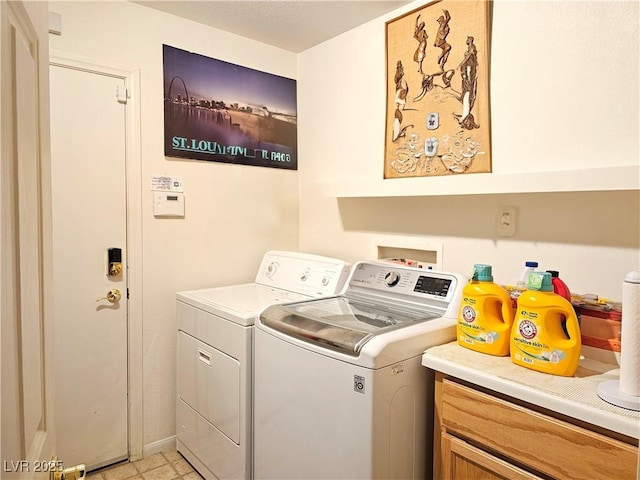 clothes washing area with cabinets and washer and dryer