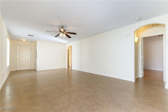 tiled spare room featuring ceiling fan