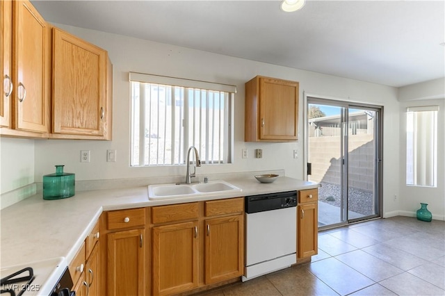 kitchen featuring a healthy amount of sunlight, sink, dishwasher, and light tile patterned flooring