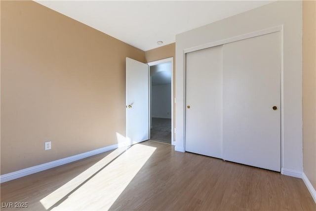 unfurnished bedroom featuring wood-type flooring and a closet