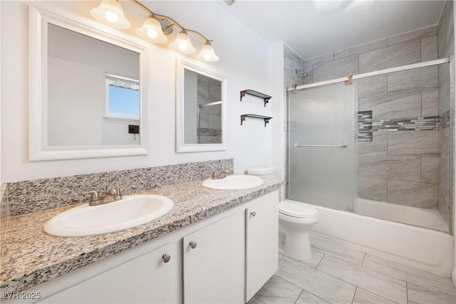 full bathroom with vanity, enclosed tub / shower combo, and toilet