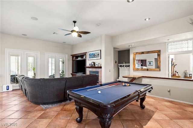 rec room with pool table, ceiling fan, light tile patterned floors, and a fireplace