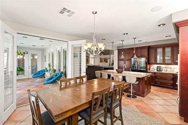 dining space featuring light tile patterned flooring and a notable chandelier