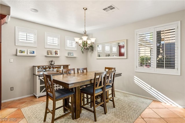 dining area with light tile patterned floors and an inviting chandelier