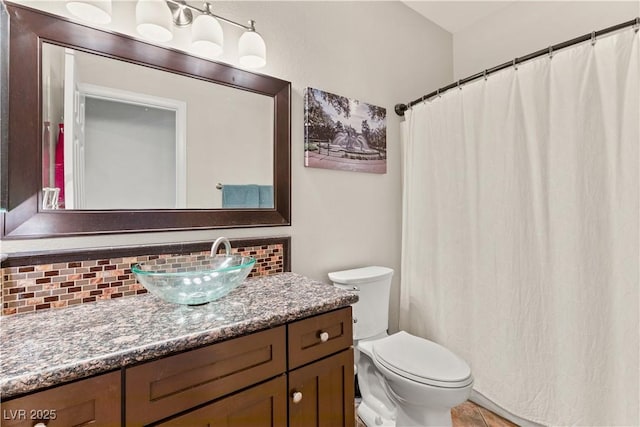 bathroom with tile patterned floors, vanity, toilet, and backsplash