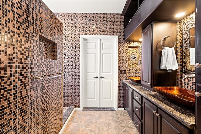 bathroom featuring tile walls, vanity, tile patterned flooring, and a shower